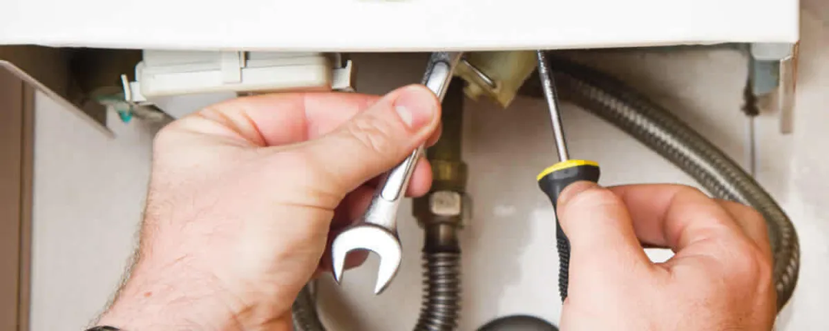 Boiler repair technician tightening pipe fittings and connections in Worcester, MA