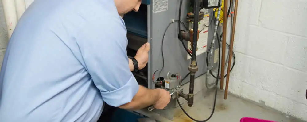 Furnace repair technician inspecting and servicing a home heating system in Worcester, MA