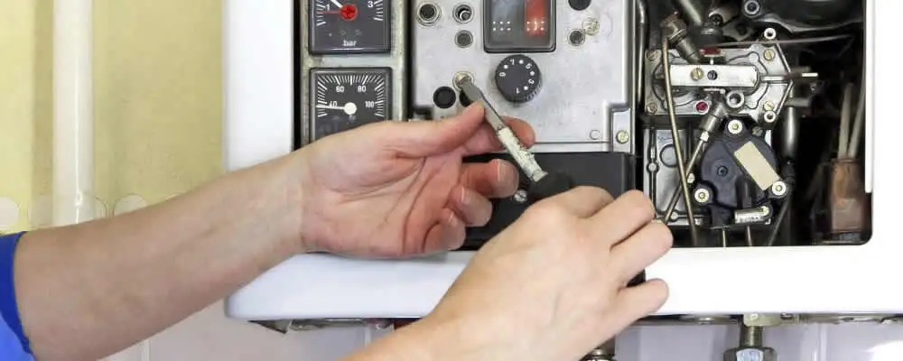 Heating repair technician adjusting boiler controls and components in Worcester, MA