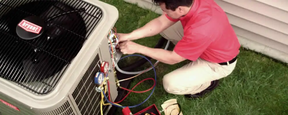HVAC technician servicing an outdoor air conditioner unit in Worcester, MA