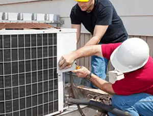 HVAC technicians repairing an outdoor AC unit on a rooftop in Worcester, MA