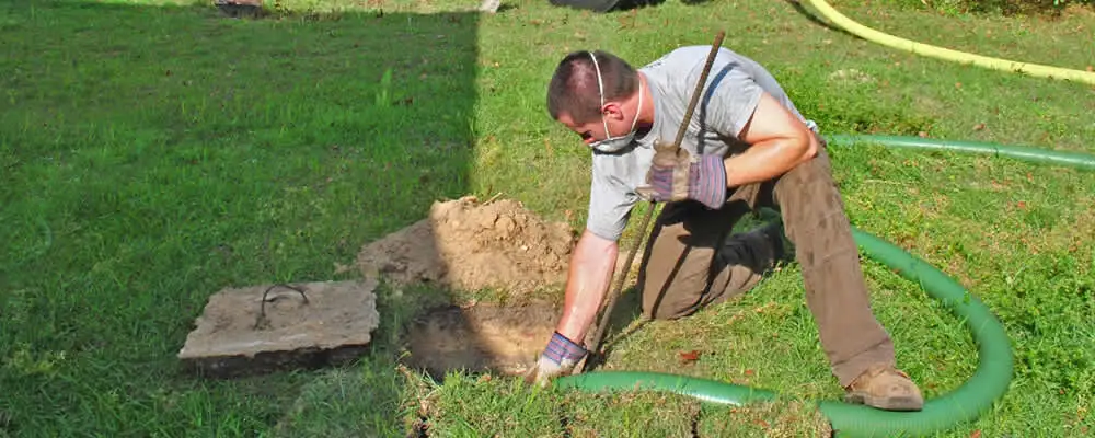 Septic pumping technician servicing a residential septic tank in Worcester, MA