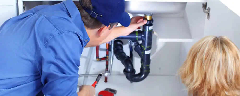 Plumber repairing under-sink drain pipes and fittings in Worcester, MA